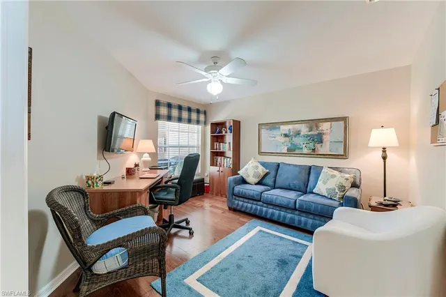 a living room with furniture a flat screen tv and a window