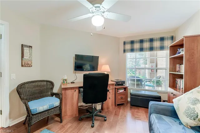 a view of a livingroom with workspace and a window