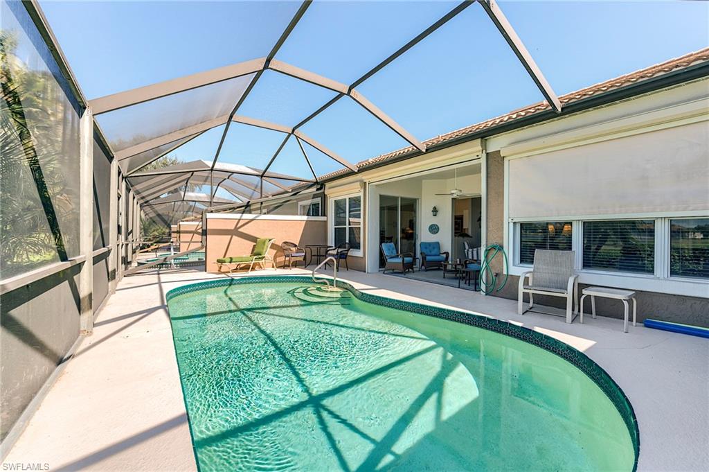 9049 Spring Run Boulevard Estero, FL 34135 - Photo 30 of 36 a swimming pool with outdoor seating and yard