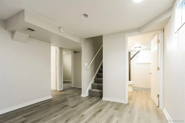an empty room with wooden floor and entryway