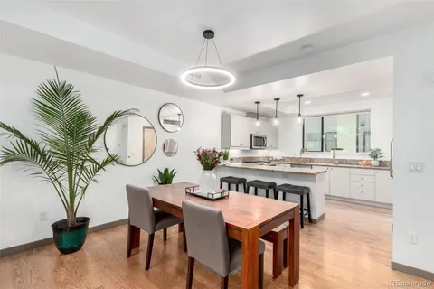 a kitchen with stainless steel appliances granite countertop a table chairs and white cabinets