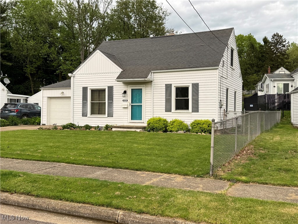 1139 Kessel Avenue Akron, OH 44310 - Photo 2 of 36 View of front of house featuring an attached garage, roof with shingles, driveway, board and batten siding, and a chimney