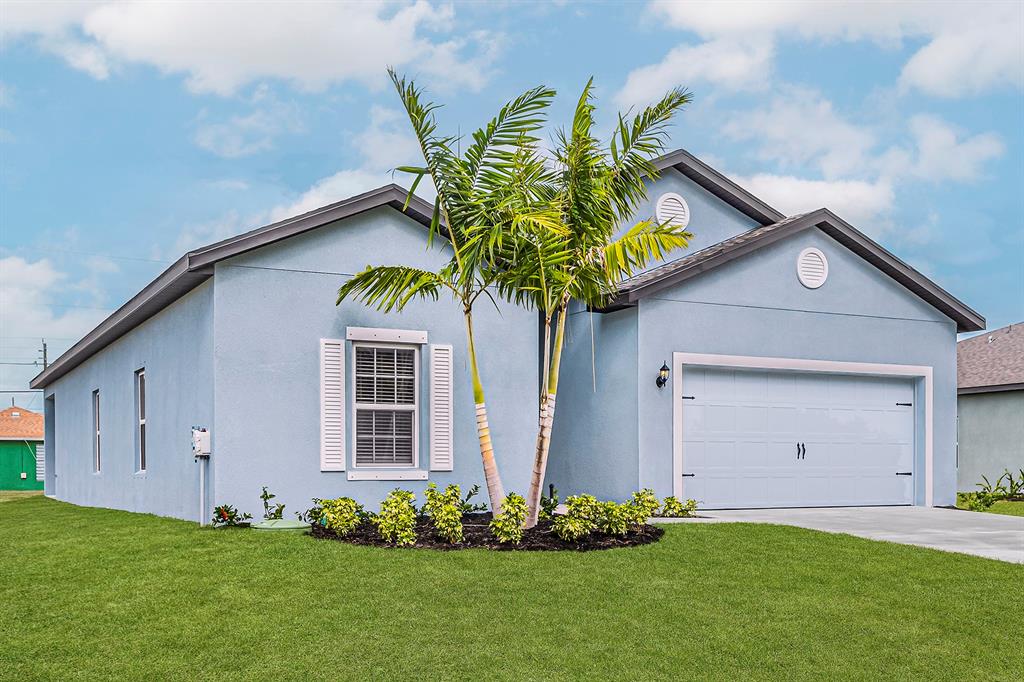 7886 99th Court Vero Beach, FL 32967 - Photo 2 of 18 a front view of a house with a garden