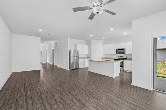 a view of kitchen with refrigerator microwave and stove with wooden floor