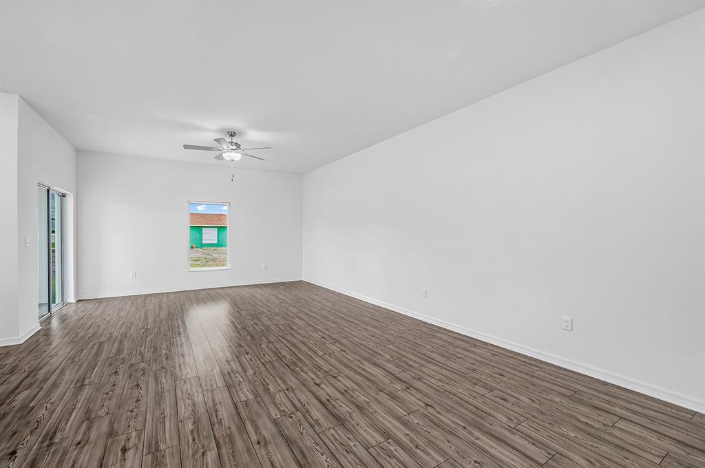 7886 99th Court Vero Beach, FL 32967 - Photo 5 of 18 a view of an empty room with wooden floor and window