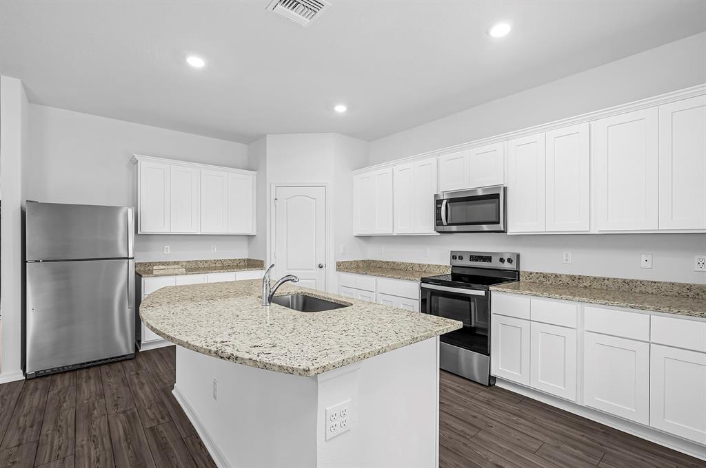 7886 99th Court Vero Beach, FL 32967 - Photo 7 of 18 a kitchen with granite countertop a sink stove and refrigerator