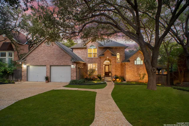 a front view of a house with a yard and trees