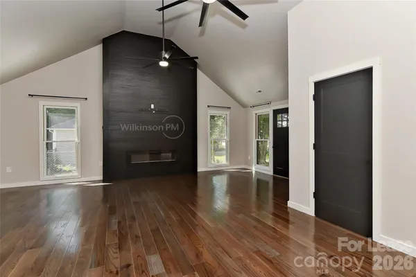 a view of an empty room with wooden floor and closet