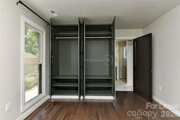 a view of empty room with wooden floor