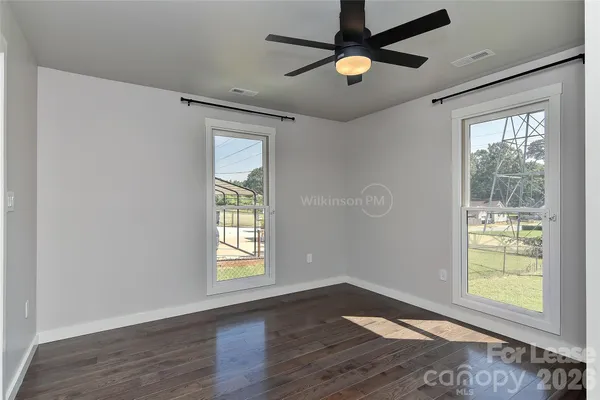 an empty room to hallway with wooden floor