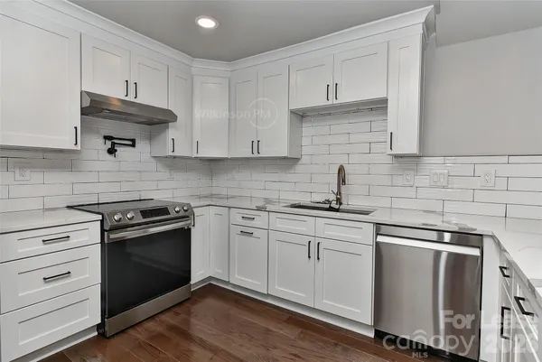 a kitchen with stainless steel appliances granite countertop a sink stove and cabinets