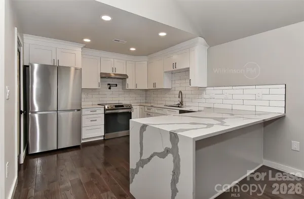 a kitchen with a sink stainless steel appliances and white cabinets