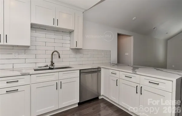 a kitchen with white cabinets white appliances and sink