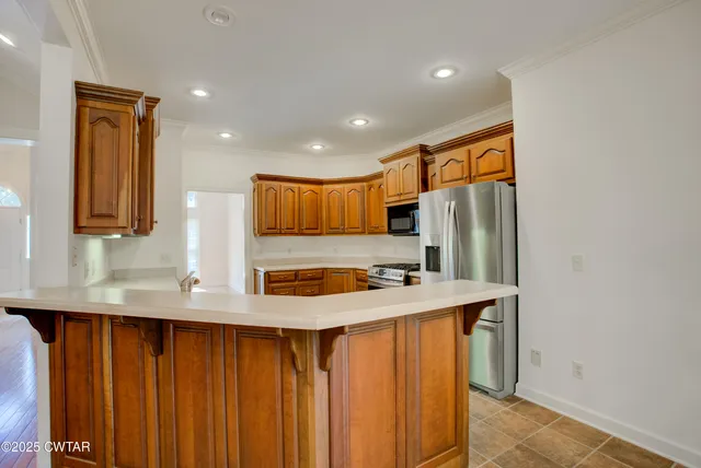 a kitchen with stainless steel appliances granite countertop a refrigerator and a sink