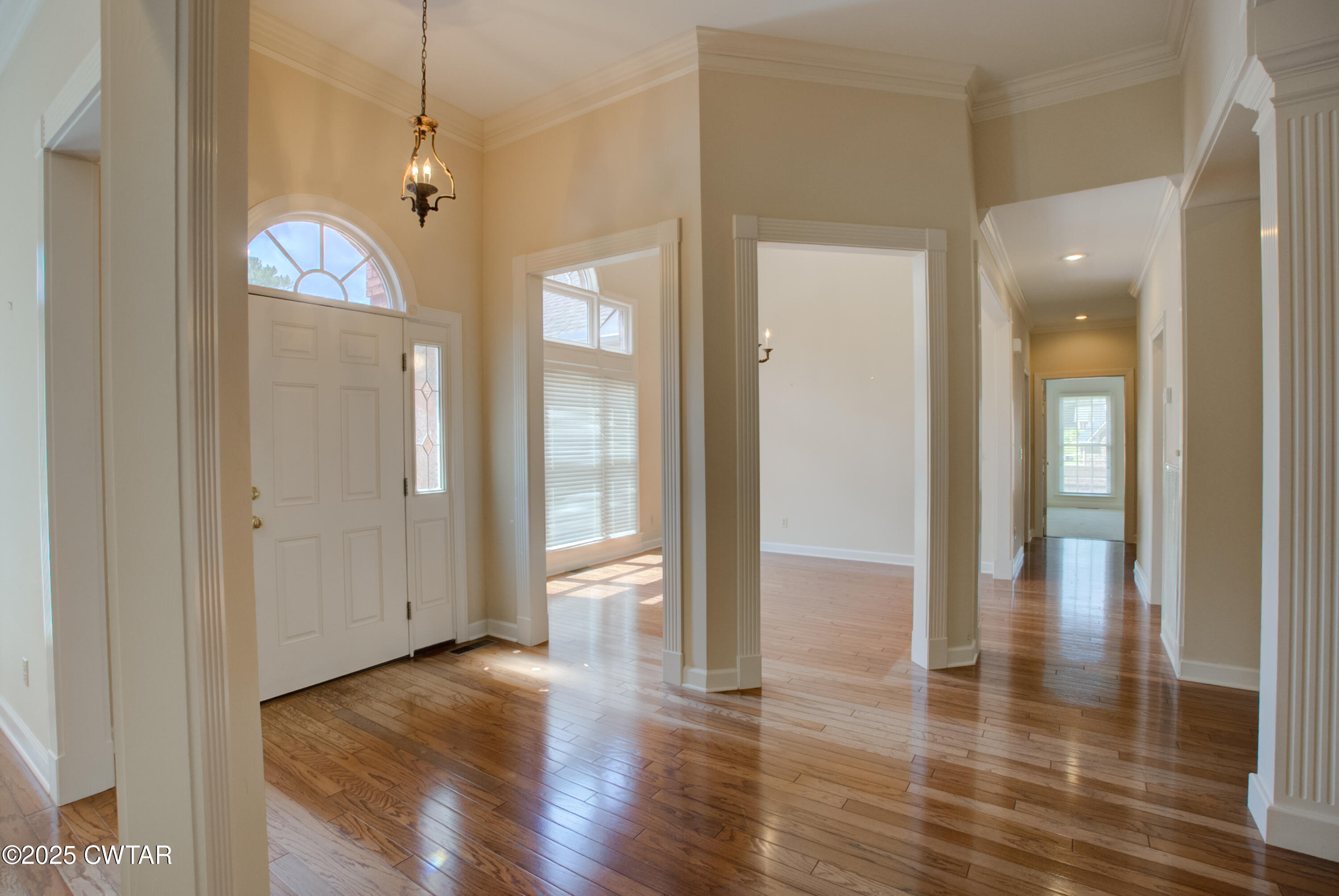 7 Sutton Place Jackson, TN 38305 - Photo 9 of 25 a view of a hallway with wooden floor and chandelier