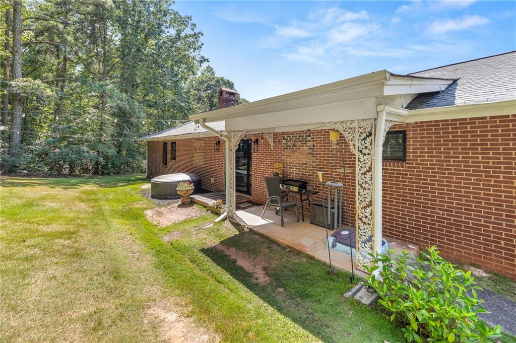 6470 Samoa Way Flowery Branch, GA 30542 - Photo 58 of 61 a view of a patio with table and chairs under an umbrella