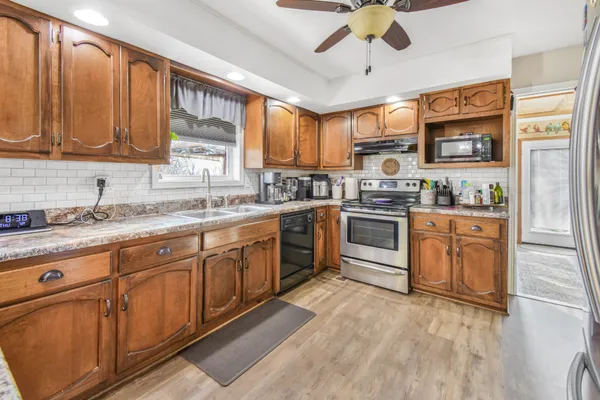 a kitchen with stainless steel appliances granite countertop a stove sink and cabinets