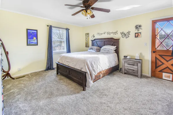 a spacious bedroom with a bed and a chandelier