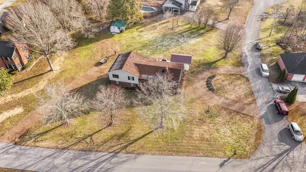 a aerial view of a house with pool plants and large trees