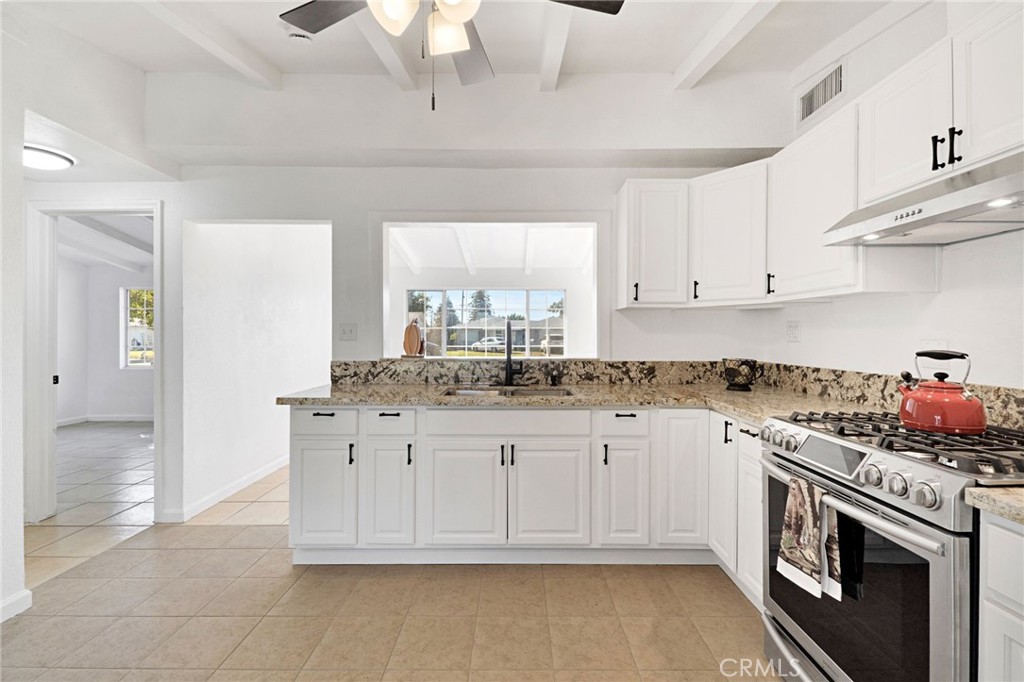 27331 Perkins Road Madera, CA 93637 - Photo 10 of 25 a kitchen with granite countertop a stove sink and cabinets
