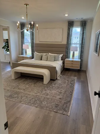 a spacious bedroom with a bed a mirror and couch