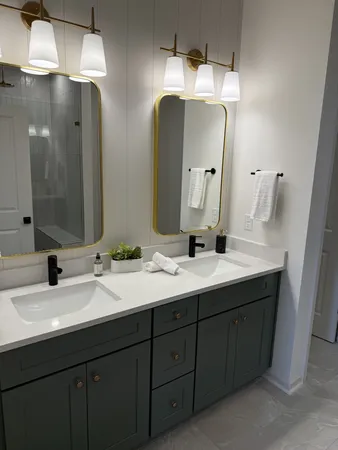 a bathroom with double vanity sinks and a mirror