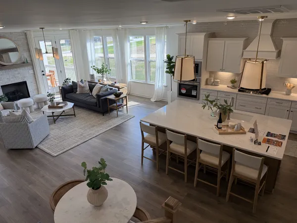 a kitchen with stainless steel appliances kitchen island granite countertop a table chairs and a refrigerator