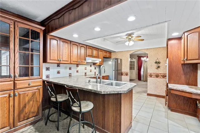 a kitchen with stainless steel appliances kitchen island granite countertop a sink and cabinets