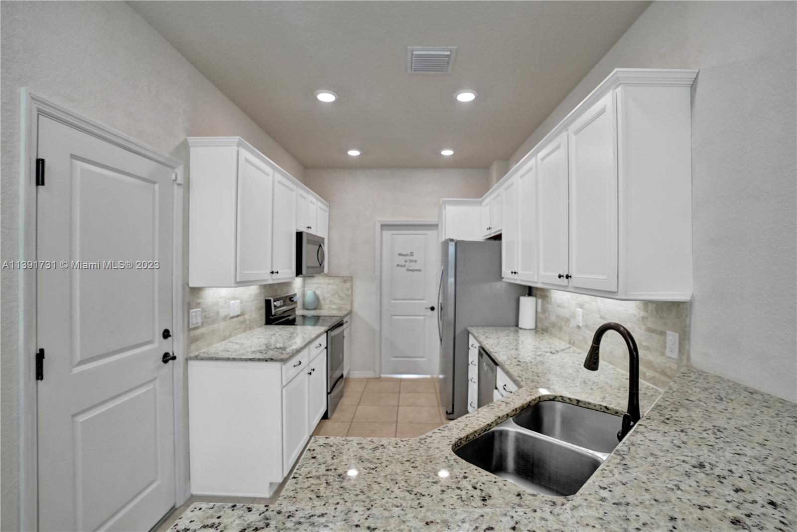 5060 Eucalyptus Drive, Unit 2 Hollywood, FL 33021 - Photo 11 of 56 a kitchen with stainless steel appliances granite countertop a sink stove and refrigerator