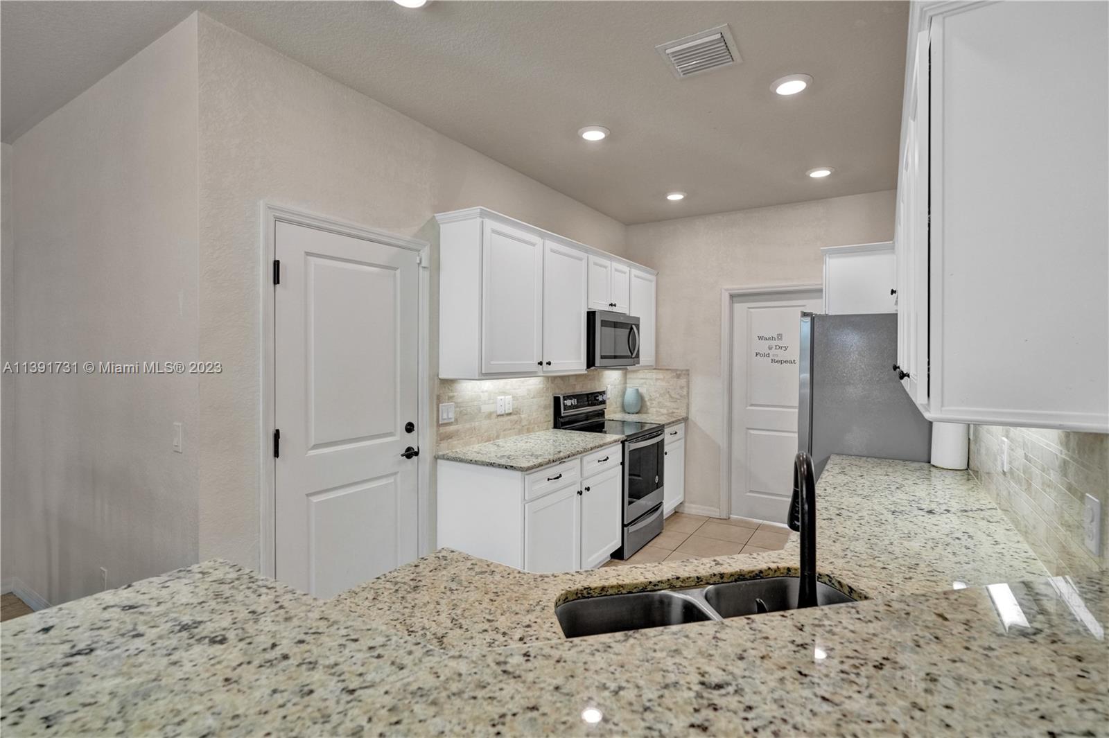 5060 Eucalyptus Drive, Unit 2 Hollywood, FL 33021 - Photo 13 of 56 a kitchen with a sink cabinets and refrigerator