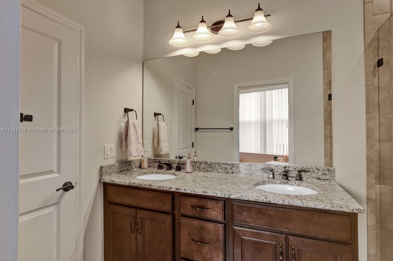 5060 Eucalyptus Drive, Unit 2 Hollywood, FL 33021 - Photo 21 of 56 a bathroom with a granite countertop sink and a mirror