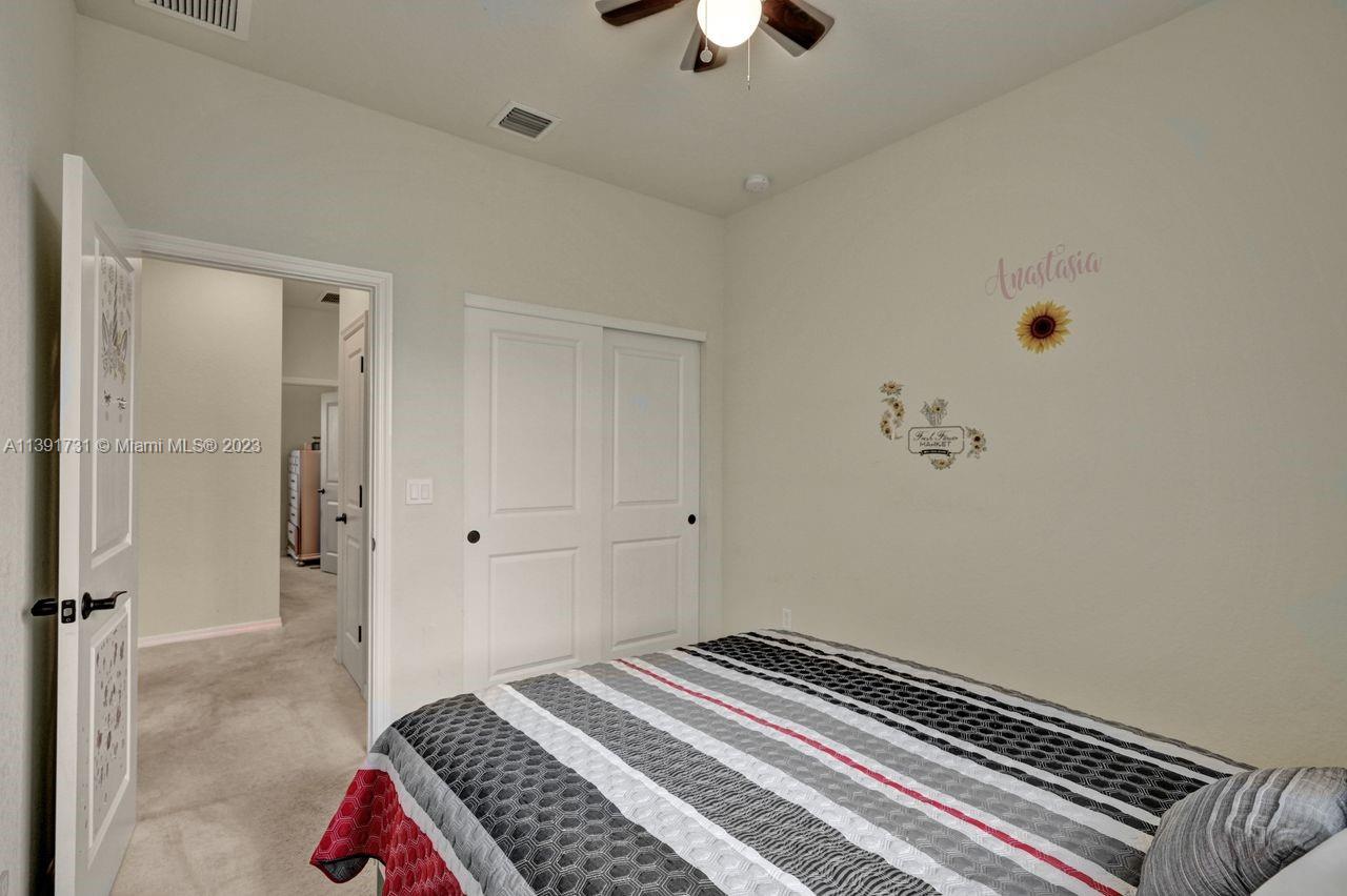 5060 Eucalyptus Drive, Unit 2 Hollywood, FL 33021 - Photo 26 of 56 a bedroom with a bed and a chandelier