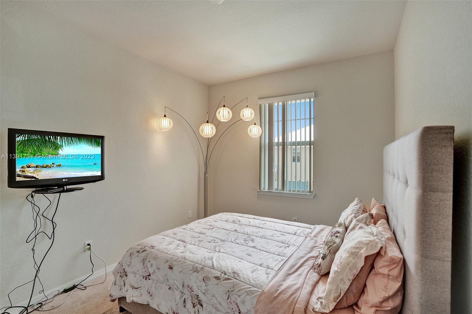 5060 Eucalyptus Drive, Unit 2 Hollywood, FL 33021 - Photo 28 of 56 a bedroom with a bed and a flat screen tv