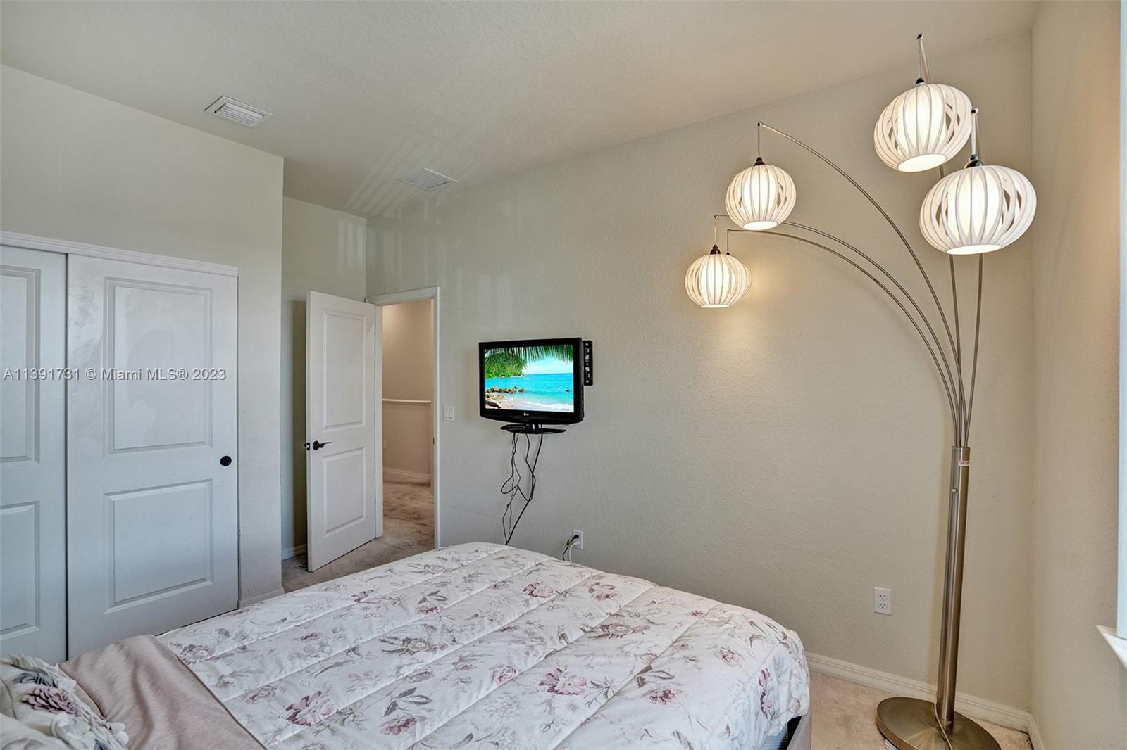 5060 Eucalyptus Drive, Unit 2 Hollywood, FL 33021 - Photo 29 of 56 a bedroom with a bed and a chandelier