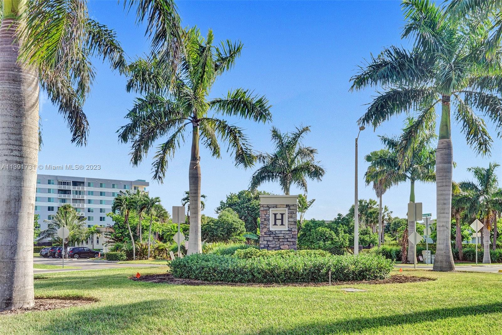 5060 Eucalyptus Drive, Unit 2 Hollywood, FL 33021 - Photo 54 of 56 a front view of multi story residential apartment building with yard and green space