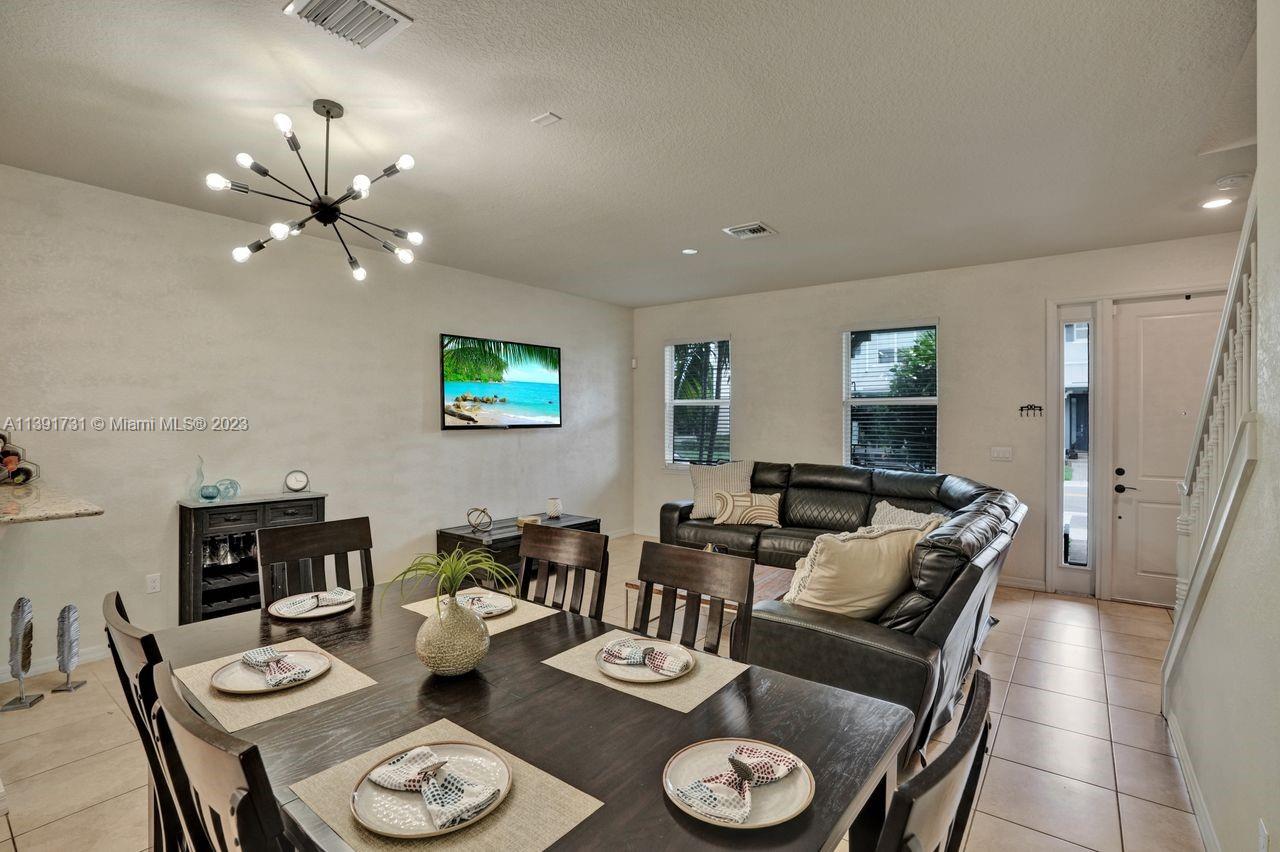 5060 Eucalyptus Drive, Unit 2 Hollywood, FL 33021 - Photo 6 of 56 a living room with furniture a fireplace and a chandelier