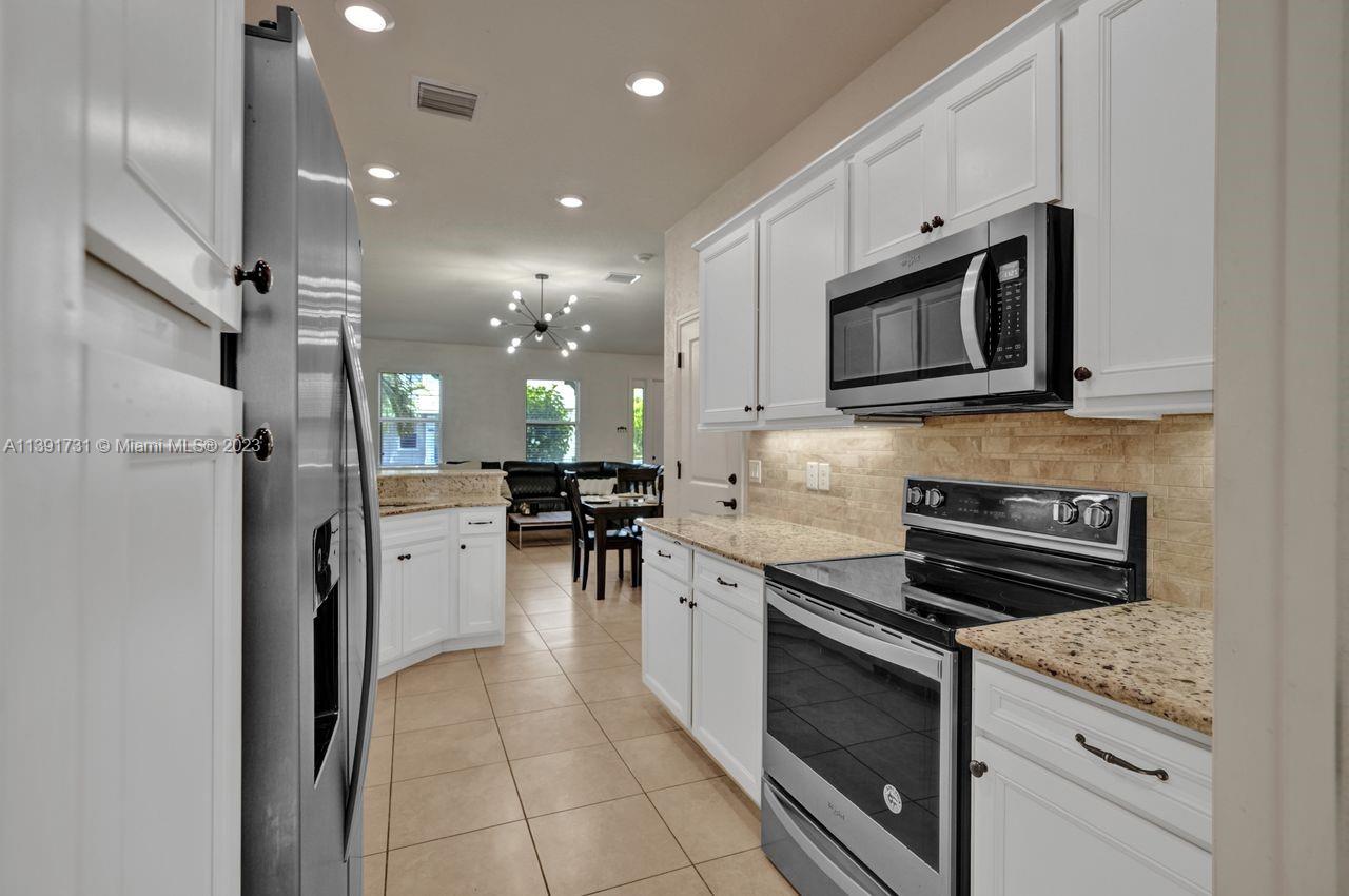 5060 Eucalyptus Drive, Unit 2 Hollywood, FL 33021 - Photo 8 of 56 a kitchen with stainless steel appliances granite countertop a stove microwave and refrigerator