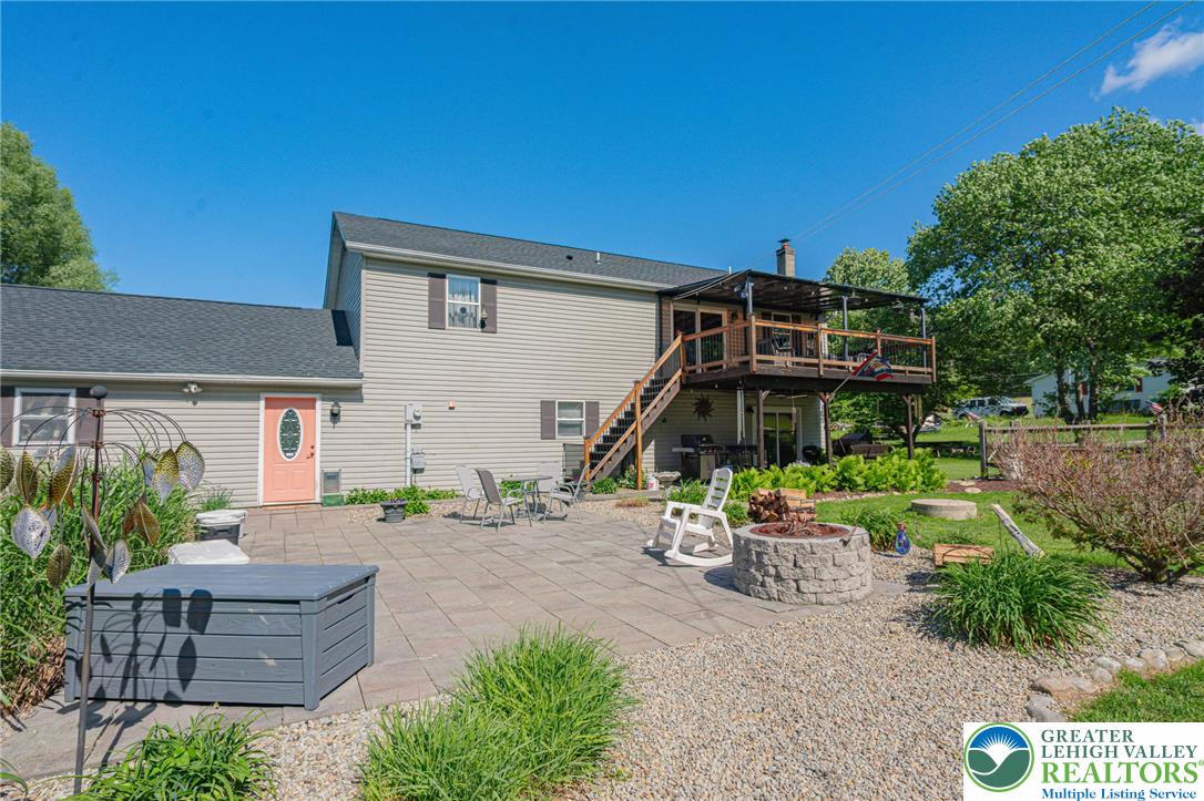 341 Lower Greenhill Road Kunkletown, PA 18058 - Photo 54 of 69 A tiered outdoor living space features a spacious patio with a fire pit and an elevated deck for entertaining.