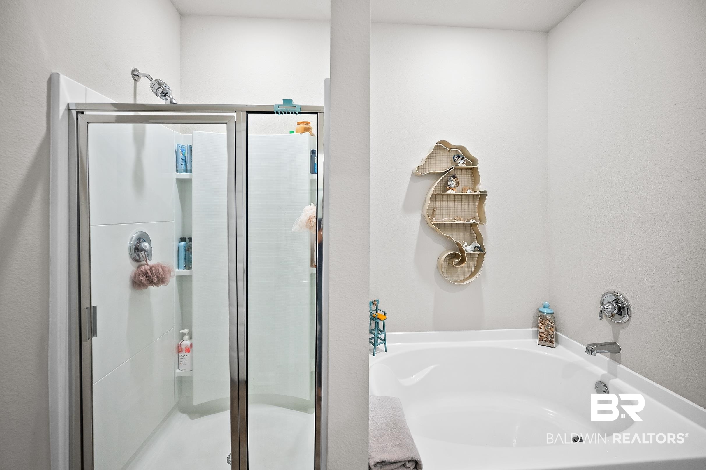 23997 Veranda Circle Elberta, AL 36530 - Photo 18 of 28 Shower enclosure with clear glass door, built-in shelving, and a separate soaking tub with chrome fixtures