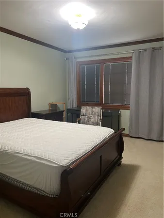 a bed sitting in a bedroom next to a window