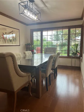 a dining room with furniture a chandelier and wooden floor
