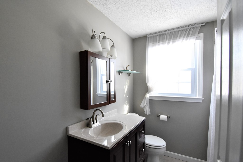 38 Juniper Road, Unit R Derry, NH 03038 - Photo 17 of 22 a bathroom with a toilet sink and mirror