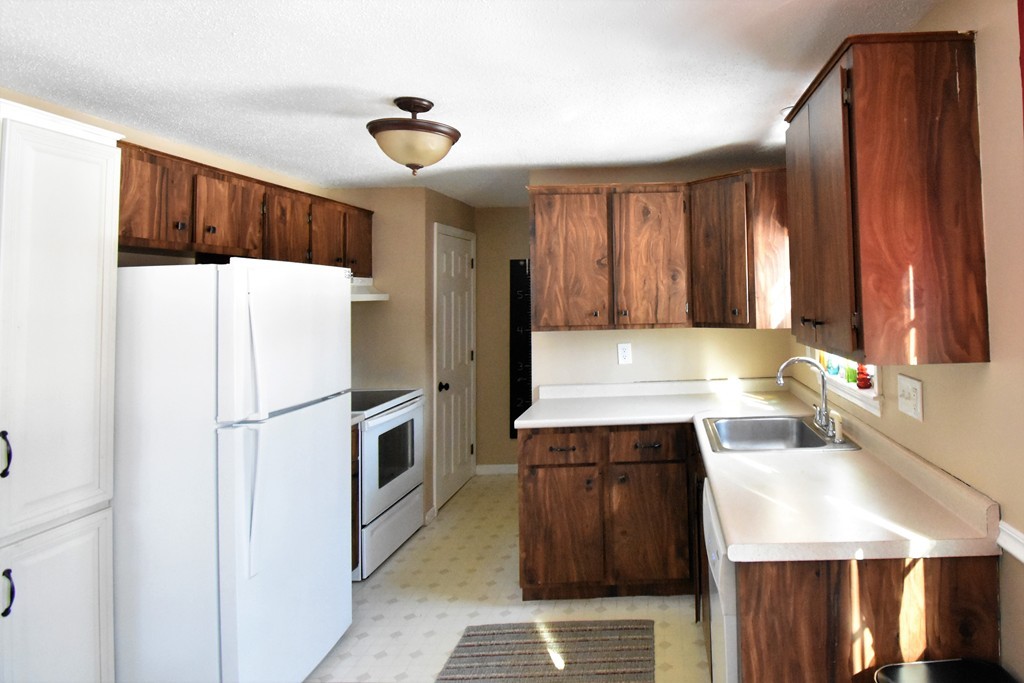 38 Juniper Road, Unit R Derry, NH 03038 - Photo 4 of 22 a kitchen with a refrigerator sink and cabinets