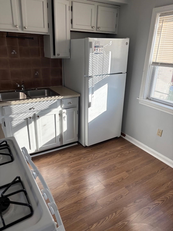 a view of a kitchen with a sink wooden cabinets and a window