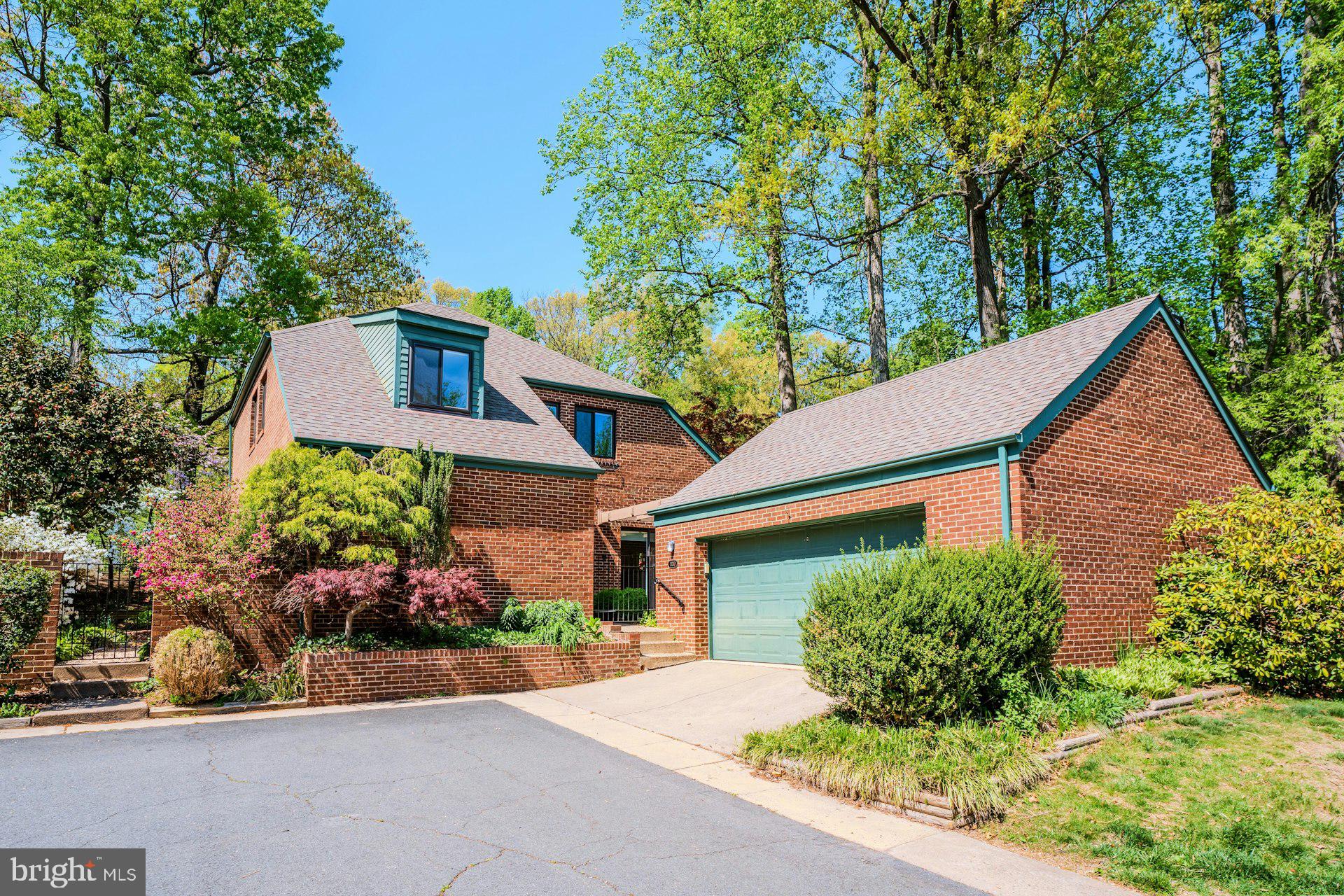 Charming brick home amid lush greenery.
