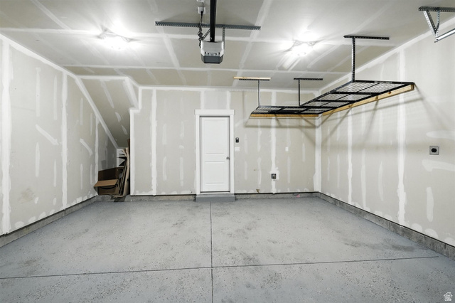 1221 West 1870 South Logan, UT 84321 - Photo 16 of 20 Spacious garage featuring a durable epoxy floor coating, overhead storage rack system, and a convenient interior access door