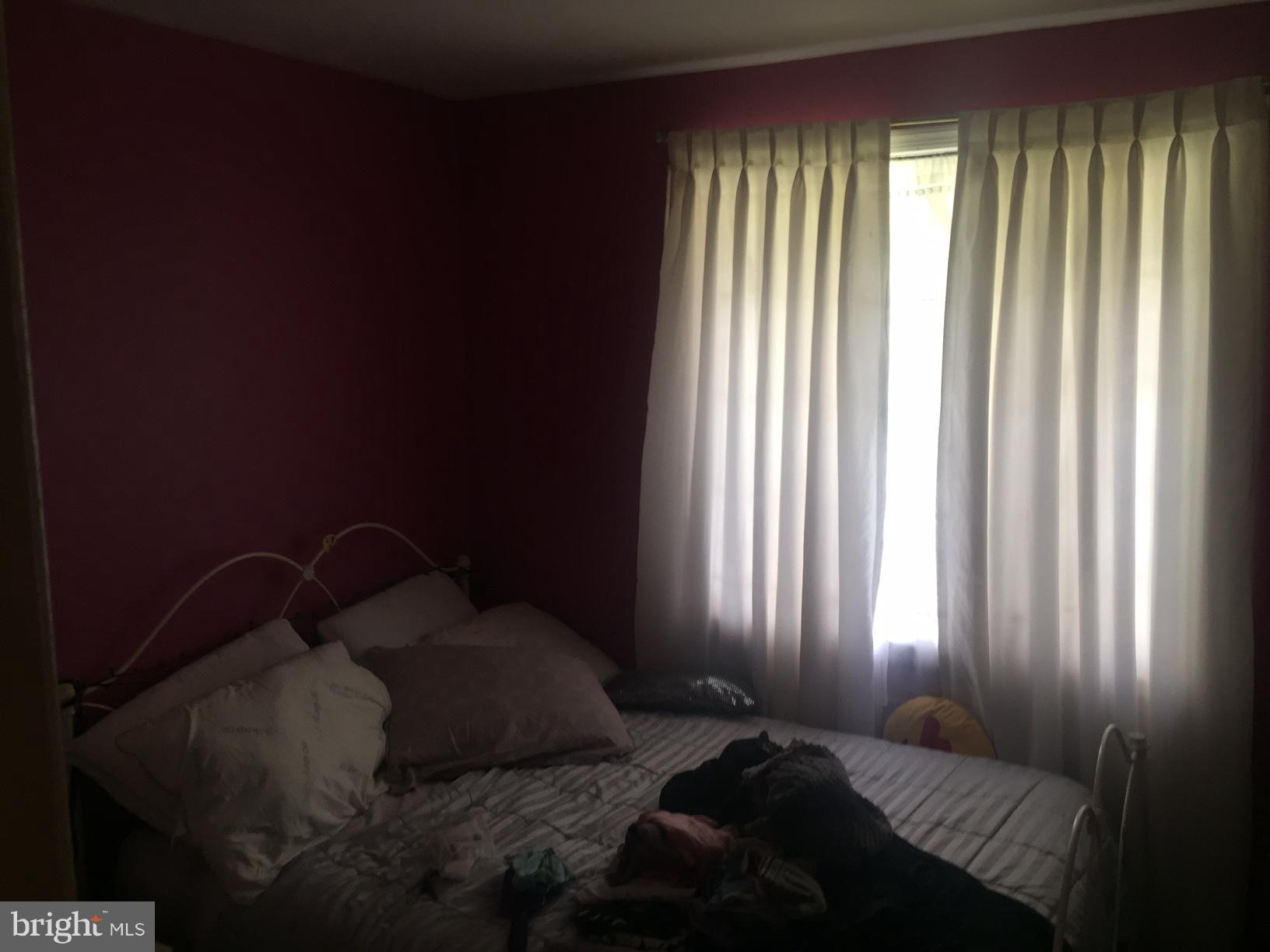 7137 Rice Street Falls Church, VA 22042 - Photo 7 of 17 a bed sitting in a bedroom next to a window