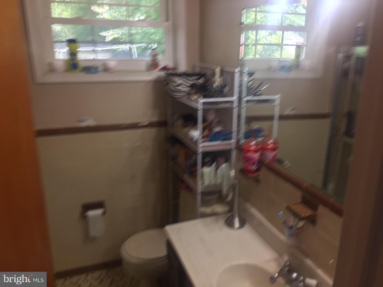 7137 Rice Street Falls Church, VA 22042 - Photo 10 of 17 a bathroom with a sink toilet and window