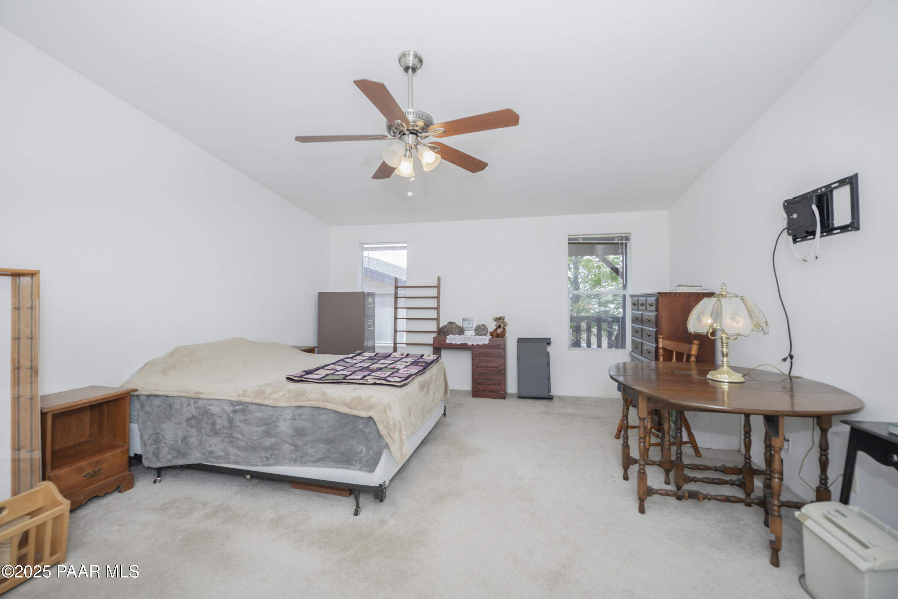 17985 East Hunters Lane Dewey, AZ 86327 - Photo 25 of 41 a bedroom with a bed a desk and a chandelier