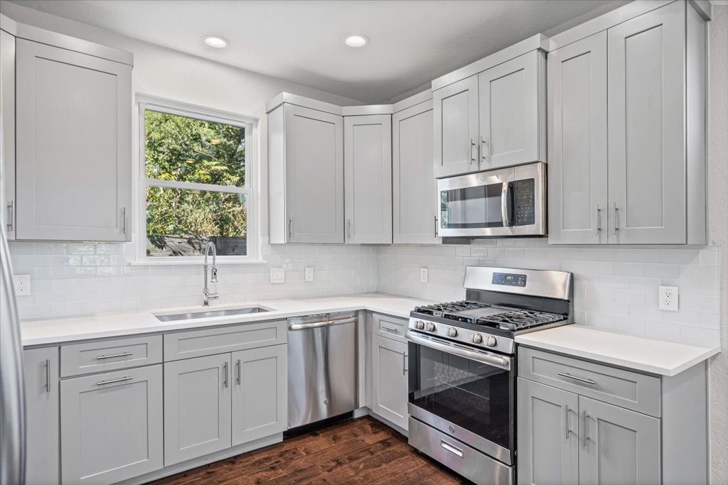 706 Short Kemp Street, Unit 2 Austin, TX 78741 - Photo 12 of 34 a kitchen with white cabinets appliances and a window